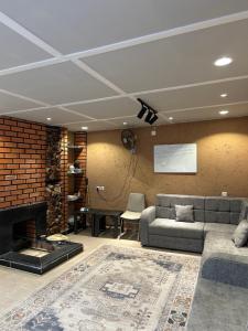 a living room with a couch and a fireplace at The Mountain View in Al Namas in Al Namas