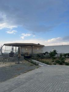 a building with a pavilion next to the water at The Mountain View in Al Namas in Al Namas