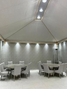 a dining room with tables and chairs and a wall at The Mountain View in Al Namas in Al Namas