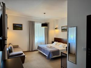 a hotel room with a bed and a chair at Sandomiria in Sandomierz