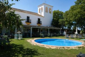 ein Gebäude mit einem Swimmingpool im Hof in der Unterkunft Hacienda El Santiscal in Arcos de la Frontera