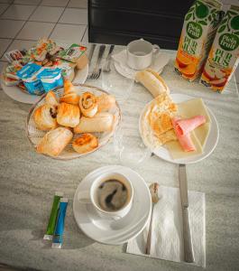a table with plates of food and a cup of coffee at Sev'hotel in Sévérac-le-Château