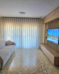 a living room with a couch and a television at Entire Apartment near Valencia - 2 Bedrooms & 2 Bathrooms in Paterna