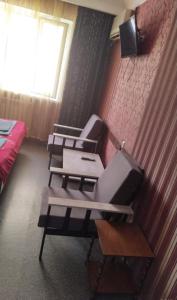 a room with three chairs and a tv on a wall at Гостиница Роза in Almaty
