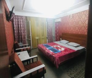 a bedroom with a bed with a red comforter at Гостиница Роза in Almaty