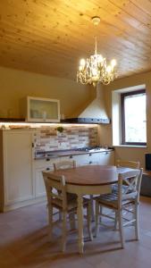 a kitchen with a table and chairs and a chandelier at Agriturismo Al Respiro Nel Bosco in Camporotondo di Fiastrone