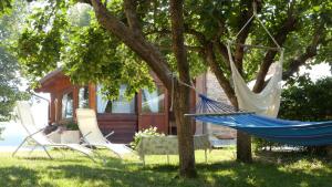 two chairs and a hammock in front of a house at Agriturismo Al Respiro Nel Bosco in Camporotondo di Fiastrone