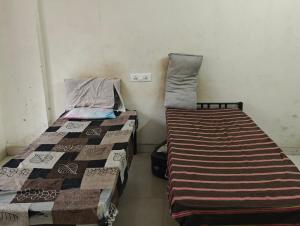 two beds sitting next to each other in a room at Shree Sai Ram PG in Pune
