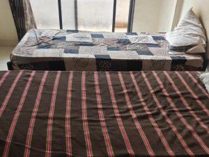 two beds in a room with a quilt on them at Shree Sai Ram PG in Pune