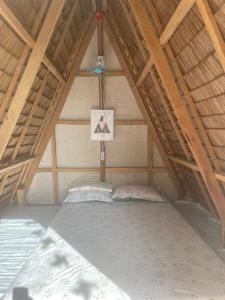 a bed in a attic with a wooden ceiling at Isla Malaya Tours Campsite in Mantangule Island +1 photo