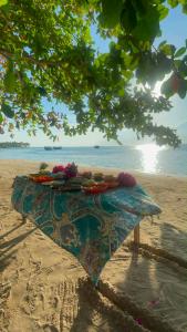 a table on the beach with flowers on it at Isla Malaya Tours Campsite in Mantangule Island