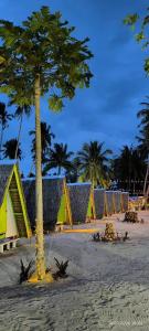 a beach with palm trees and colorful beach huts at Isla Malaya Tours Campsite in Mantangule Island