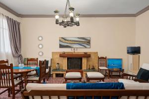 a living room with a fireplace and tables and chairs at Villa Amalia Laconia in Dháfnion
