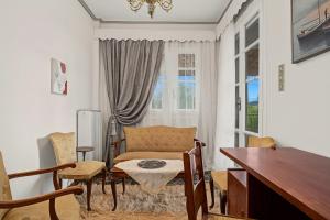 a living room with a couch and a table and chairs at Villa Amalia Laconia in Dháfnion