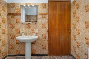 a bathroom with a sink and a wooden door at Villa Amalia Laconia in Dháfnion +39 photos