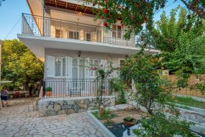 a large house with a balcony and a courtyard at Villa Amalia Laconia in Dháfnion