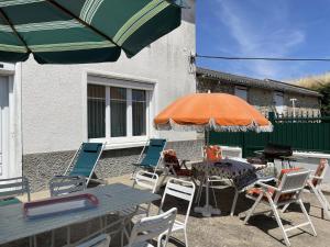 a patio with a table and chairs and an umbrella at Gîte de la lionnaire in Orches
