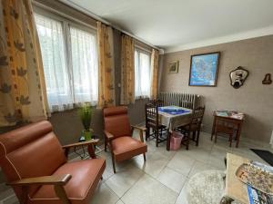 a living room with chairs and a table and a dining room at Gîte de la lionnaire in Orches
