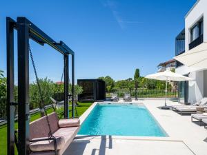 a swimming pool in a yard with a swing at Villa Loparia by Interhome in Lopar