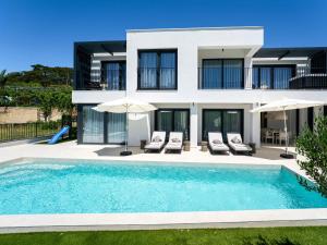 a villa with a swimming pool in front of a house at Villa Loparia by Interhome in Lopar