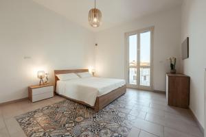 a white bedroom with a bed and a large window at The White House in Miglianico