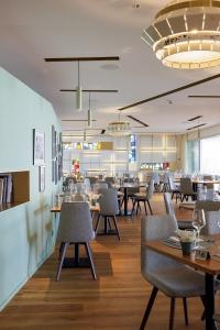 a dining room with tables and chairs and a restaurant at Hotel du Léman - Jongny in Vevey