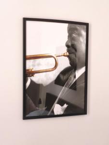 a framed picture of a man playing a trumpet at Apartments Częstochowa - Słoneczna Kamienica - Centrum - Prywatny Parking free! - Klimatyzacja ! in Częstochowa
