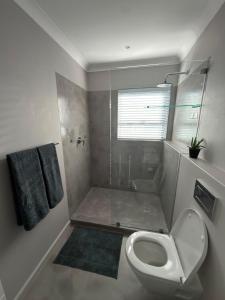a small bathroom with a toilet and a shower at Cosy Langdown Getaway in Plettenberg Bay +10 photos