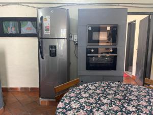 a kitchen with a stainless steel refrigerator and an oven at Espacios amplios con terraza y piscina spa in San Lorenzo