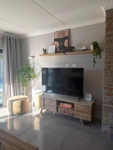 a living room with a large flat screen tv at Cosy Langdown Getaway in Plettenberg Bay