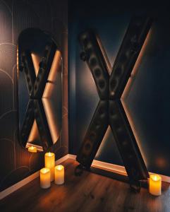 a mirror and candles in a room with a letter x at L'Eure de Luxure Loveroom Suite in Normandy in Évreux