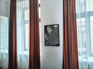 a picture of a man on a wall next to windows at Apartments Częstochowa - Słoneczna Kamienica - Centrum - Prywatny Parking free! - Klimatyzacja ! in Częstochowa
