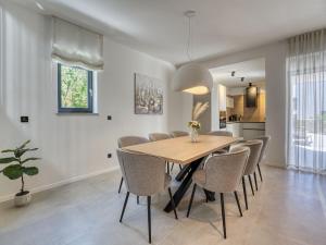 a dining room with a wooden table and chairs at Villa Dream by Interhome in Dobrinj