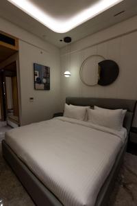 a bedroom with a large bed with white sheets at Hotel Vintana in Nananpur +2 photos