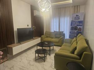 a living room with a couch and a tv at Soilsmart Haven in Abuja