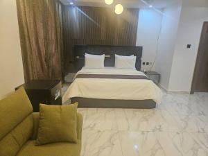 a bedroom with a large bed and a couch at Soilsmart Haven in Abuja +4 photos