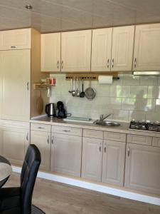 a kitchen with white cabinets and a sink at Het Kempens huisje in Lille +13 photos