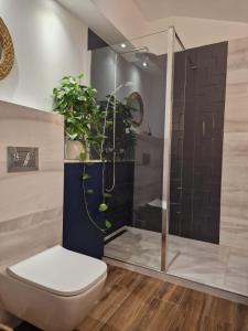 a bathroom with a toilet and a shower with plants at InOut Dom Olsztyn in Olsztyn +12 photos