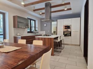 a kitchen with a wooden table and white cabinets at InOut Dom Olsztyn in Olsztyn