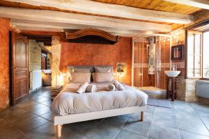 a bedroom with a large bed and a bathroom at Domaine de Cantegrel - Gîtes de Charme et Suite Troglodyte en Périgord in Vitrac +229 photos