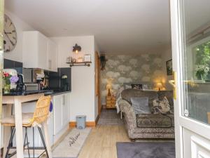 a kitchen and a living room with a couch at La'al Yan in Workington