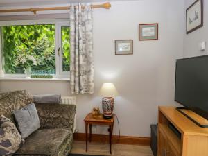 a living room with a couch and a television at La'al Yan in Workington