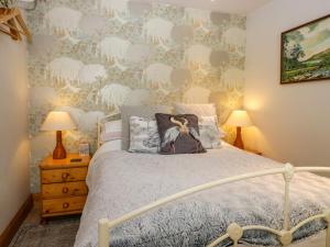 a bedroom with a bed and a wall covered in wallpaper at La'al Yan in Workington