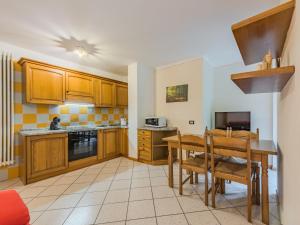 a kitchen with wooden cabinets and a table and chairs at Apartment Betulla by Interhome in Rabbi