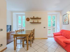 a living room with a table and a red couch at Apartment Betulla by Interhome in Rabbi