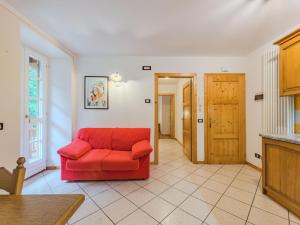a red couch in a living room with a door at Apartment Betulla by Interhome in Rabbi +13 photos