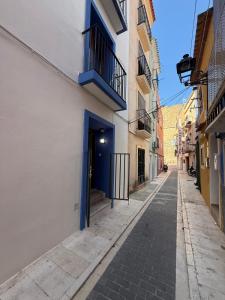 an empty alley with a blue door on a building at Casa Azul in Villajoyosa