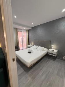 a bedroom with a large white bed and two tables at Casa Azul in Villajoyosa
