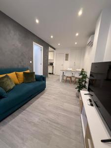a living room with a blue couch and a kitchen at Casa Azul in Villajoyosa