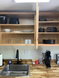 a kitchen with a sink and wooden shelves with dishes at Lodge at Chalk Hill in Uniontown +25 photos
